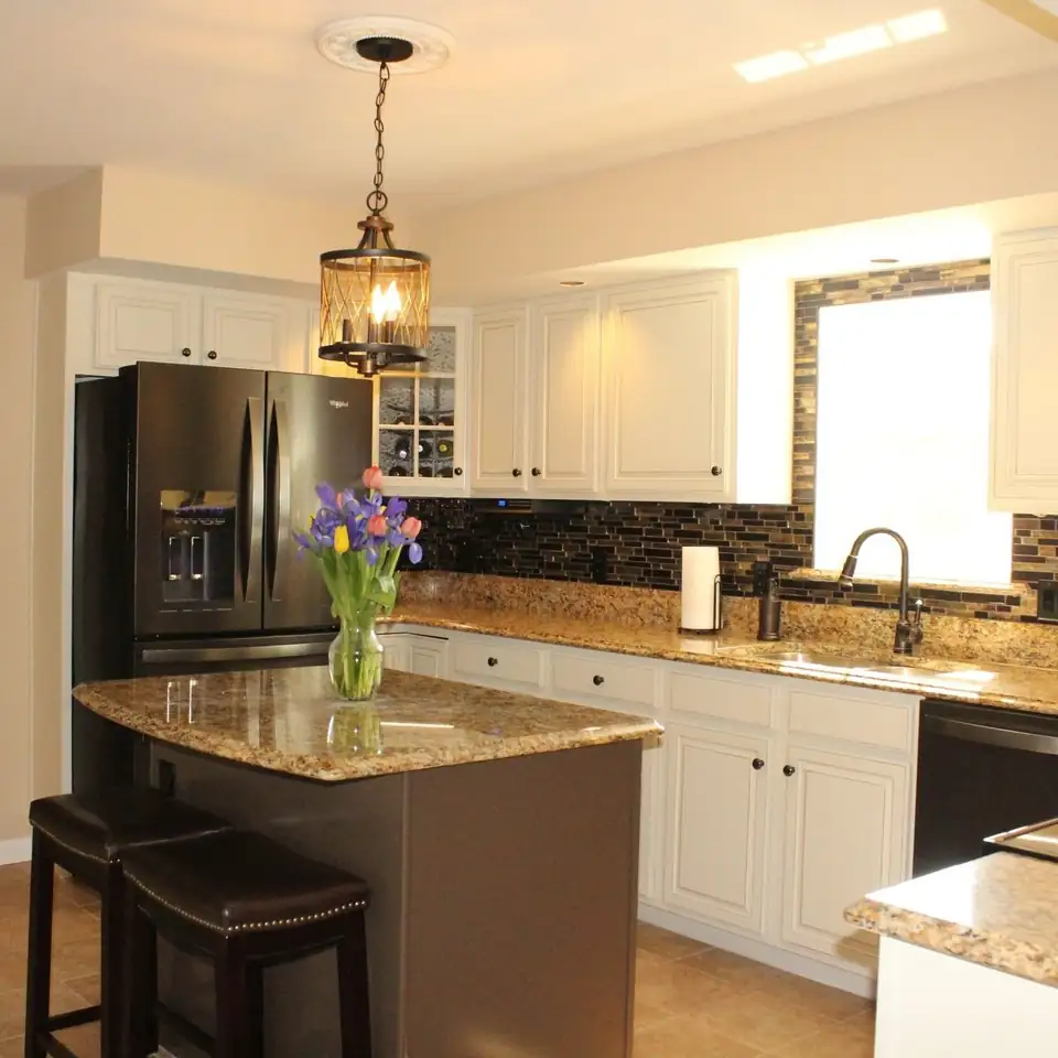 Kitchen cabinet refinishing in Dublin, VA by Morris Finishing: two-tone kitchen with white painted cabinets, a dark island, granite counters and a lantern pendant